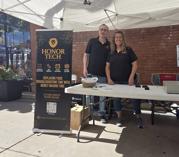 Honor Tech team members volunteering beside the Honor Tech banner at the Pueblo Chile and Frijoles Festival